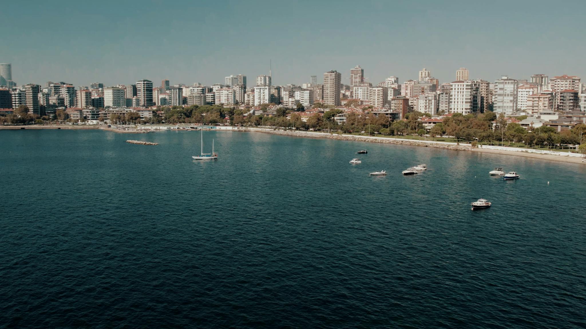 Aerial daytime view of Istanbul's scenic coastline with city skyline and boats.
